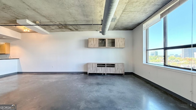interior space with heating unit, finished concrete flooring, and baseboards