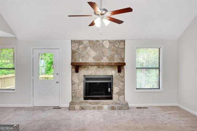 unfurnished living room with baseboards, ceiling fan, vaulted ceiling, a fireplace, and carpet floors