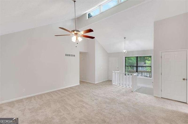 unfurnished room with carpet, high vaulted ceiling, visible vents, baseboards, and ceiling fan