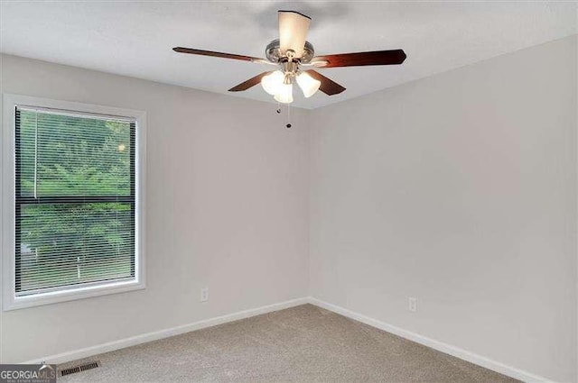 unfurnished room featuring carpet flooring, baseboards, a ceiling fan, and visible vents