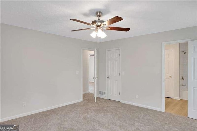 unfurnished bedroom featuring light colored carpet, a closet, baseboards, and ceiling fan