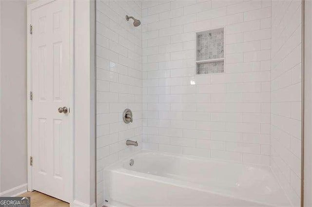bathroom featuring bathing tub / shower combination and baseboards