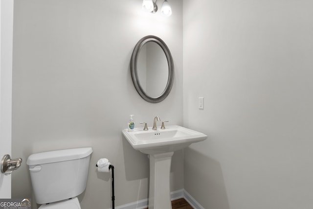bathroom with toilet and baseboards