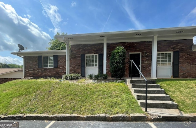view of front of property featuring brick siding and a front yard