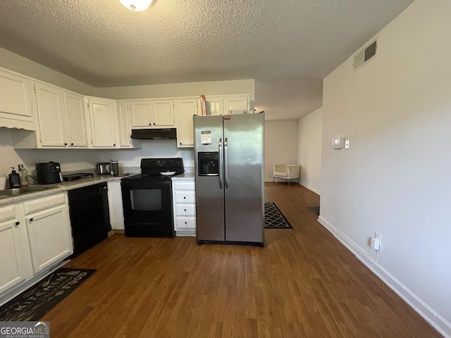 kitchen with dark wood finished floors, a sink, white cabinetry, black appliances, and light countertops