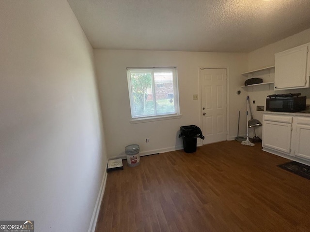 interior space featuring white cabinetry, dark wood-style flooring, baseboards, and open shelves