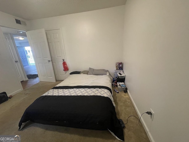 bedroom featuring baseboards, visible vents, and carpet