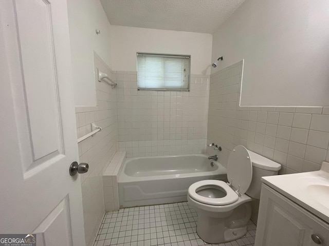 bathroom with toilet, tub / shower combination, tile walls, a textured ceiling, and tile patterned flooring