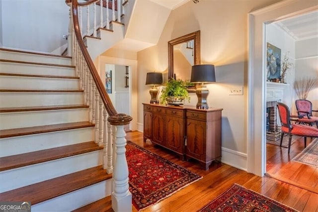 staircase with baseboards and wood finished floors