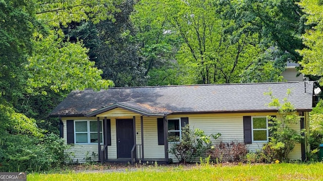 single story home featuring a shingled roof