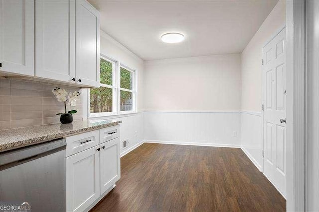 interior space featuring light stone countertops, stainless steel dishwasher, dark wood-style flooring, decorative backsplash, and white cabinets