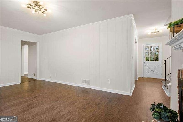 unfurnished living room with crown molding, visible vents, wood finished floors, and baseboards