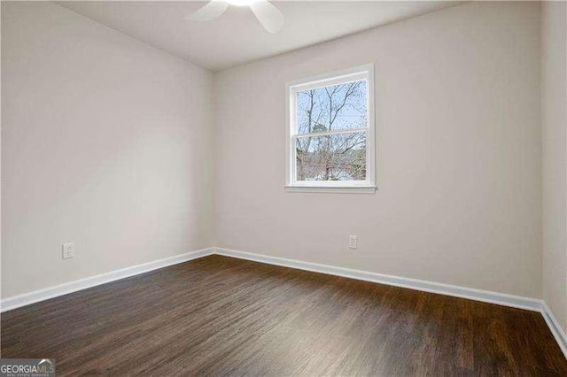 empty room with baseboards, ceiling fan, and dark wood-style floors
