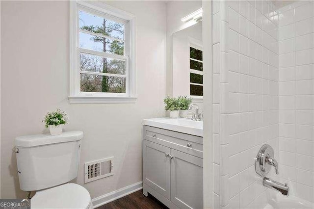 full bathroom with toilet, vanity, visible vents, shower / bath combination, and baseboards