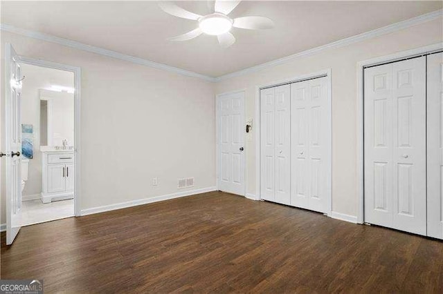 unfurnished bedroom with baseboards, multiple closets, and wood finished floors