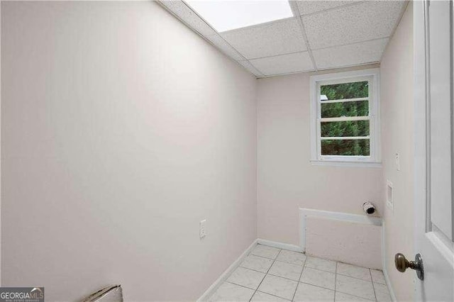 laundry room featuring baseboards and light tile patterned flooring