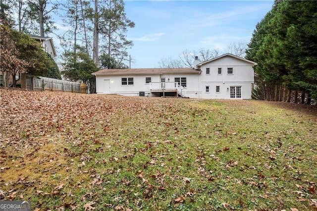back of house with a lawn and fence