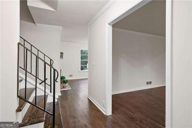 foyer with wood finished floors, crown molding, visible vents, baseboards, and stairway