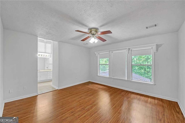 4440 Coventry Ct NE, Roswell, GA 30075 - unfurnished room with a ceiling fan, baseboards, a textured ceiling, and wood finished floors