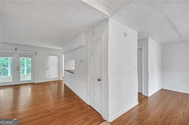 4440 Coventry Ct NE, Roswell, GA 30075 - additional living space with wainscoting, a textured ceiling, and wood finished floors