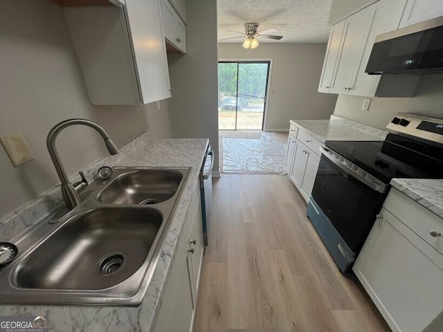 1466 Pine Log Rd NE Unit A, Conyers, GA 30012 - kitchen with ceiling fan, a sink, white cabinetry, stainless steel appliances, and light wood-type flooring