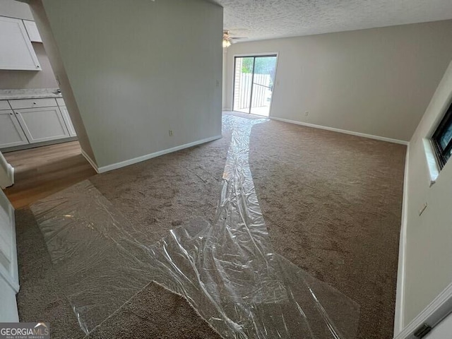 1466 Pine Log Rd NE Unit A, Conyers, GA 30012 - unfurnished living room with a textured ceiling, baseboards, ceiling fan, and carpet floors