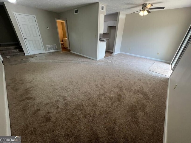 1466 Pine Log Rd NE Unit A, Conyers, GA 30012 - unfurnished living room featuring light colored carpet, visible vents, baseboards, and a ceiling fan