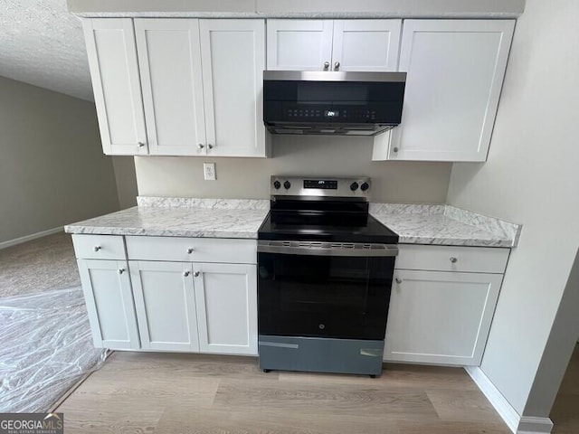 1466 Pine Log Rd NE Unit A, Conyers, GA 30012 - kitchen featuring light wood-type flooring, white cabinetry, stainless steel electric range oven, and baseboards