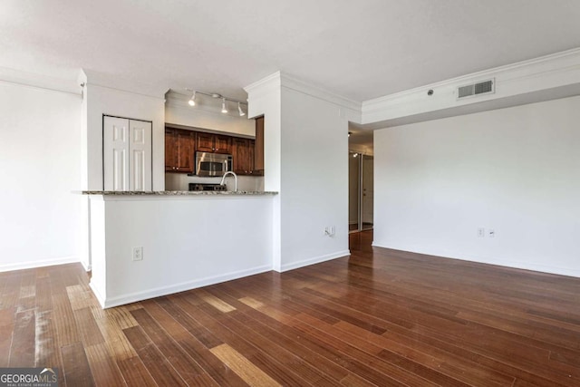 275 13th St NE Unit 605, Atlanta, GA 30309 - unfurnished living room featuring dark wood finished floors, ornamental molding, baseboards, and track lighting