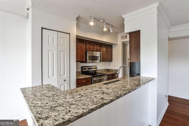 275 13th St NE Unit 605, Atlanta, GA 30309 - kitchen with stainless steel appliances, a sink, crown molding, light stone counters, and dark wood finished floors