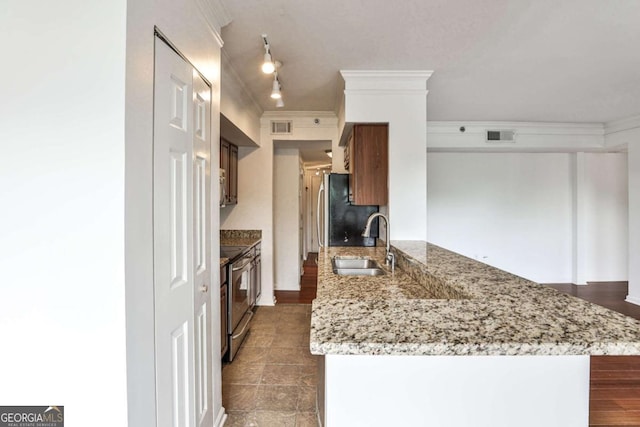 275 13th St NE Unit 605, Atlanta, GA 30309 - kitchen featuring stainless steel range with electric cooktop, a sink, ornamental molding, freestanding refrigerator, and a peninsula