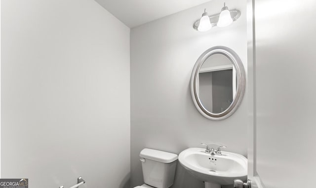 half bath featuring a sink and toilet