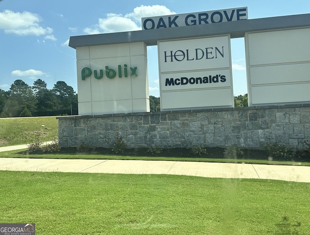 community / neighborhood sign with a yard