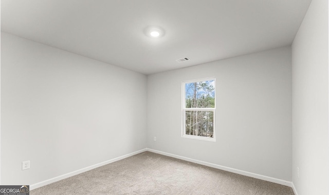 empty room featuring visible vents, baseboards, and carpet floors