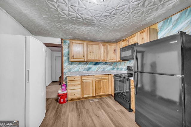 627 N Hulin Ave, Tignall, GA 30668 - kitchen featuring light countertops, light wood-style flooring, black appliances, and an ornate ceiling
