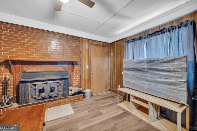 627 N Hulin Ave, Tignall, GA 30668 - unfurnished living room with crown molding, a wood stove, ceiling fan, and wood finished floors