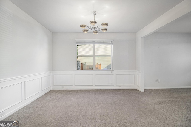 2113 Dodson Woods Dr, Fairburn, GA 30213 - carpeted empty room with a wainscoted wall, a chandelier, and a decorative wall