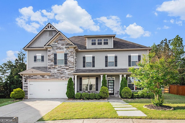 2113 Dodson Woods Dr, Fairburn, GA 30213 - craftsman-style house with fence, an attached garage, stone siding, driveway, and a front lawn