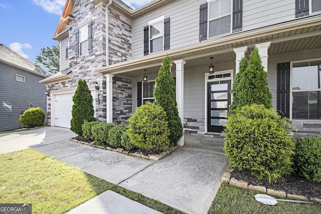 2113 Dodson Woods Dr, Fairburn, GA 30213 - entrance to property with concrete driveway, stone siding, covered porch, and a garage