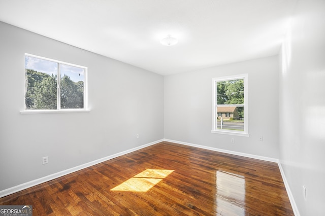 empty room with baseboards and wood finished floors