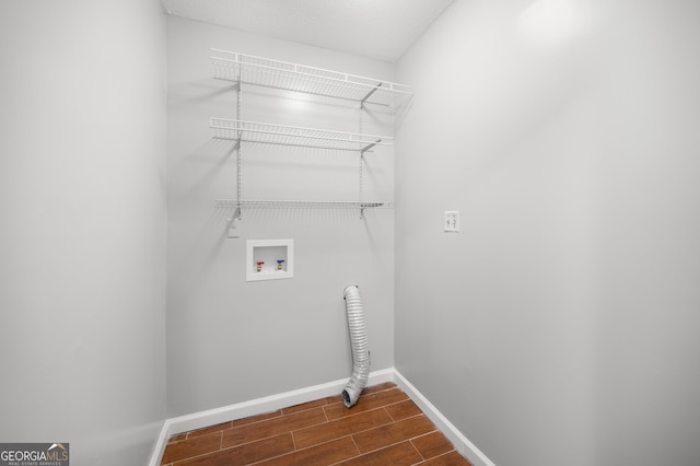 clothes washing area featuring baseboards, hookup for a washing machine, laundry area, and wood tiled floor