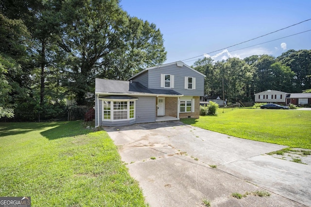 traditional home with a front lawn, brick siding, and driveway