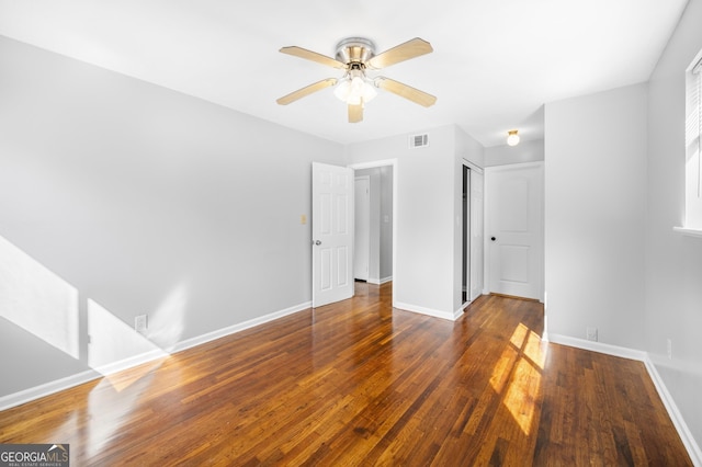 unfurnished room featuring visible vents, wood finished floors, baseboards, and ceiling fan