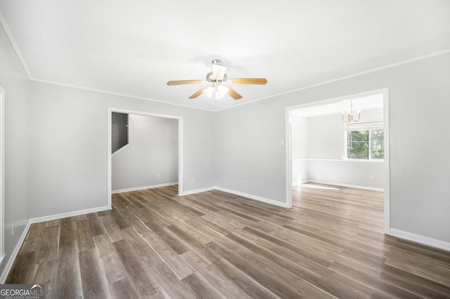unfurnished room with baseboards, ceiling fan with notable chandelier, crown molding, and wood finished floors