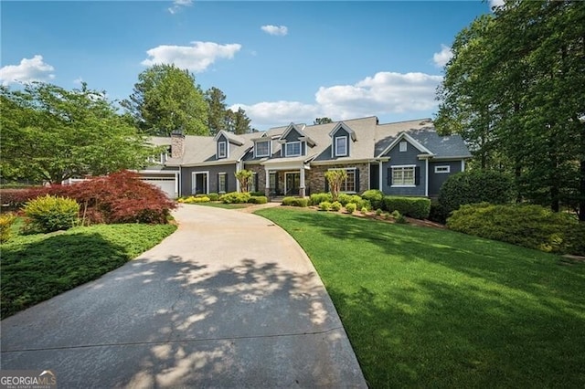 cape cod-style house with a garage, driveway, and a front yard