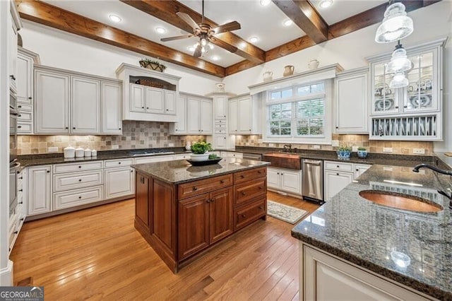 kitchen featuring light wood-style flooring, a sink, beamed ceiling, ceiling fan, and dishwasher