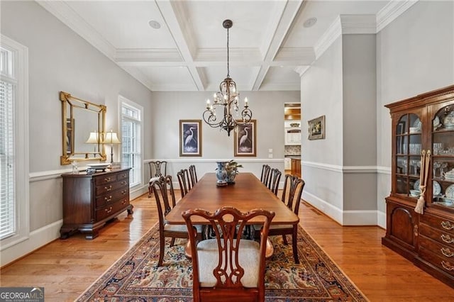 dining space featuring beam ceiling, an inviting chandelier, light wood-type flooring, and coffered ceiling