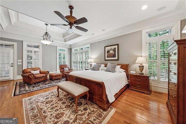 bedroom featuring multiple windows, light wood-style floors, and crown molding