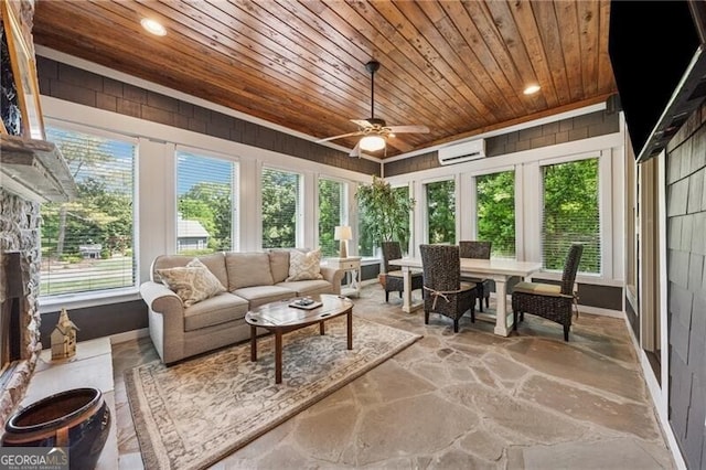 sunroom / solarium featuring wood ceiling, stone finish floor, a wall mounted AC, and recessed lighting