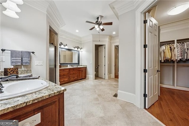 bathroom with a sink, ornamental molding, recessed lighting, a ceiling fan, and two vanities